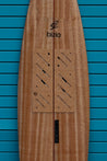 A front facing close-up of the top of the tow board highlights the bizia brand name and logo over the upper set of cork traction pads by Nomads Surfing.