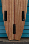 A close-up of the back of this wooden tow board reveals three futures fin slots.
