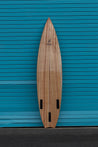 The back of the wooden tow board reveals three futures fin slots.