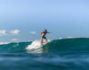 Team rider CJ Macias shows off his nose riding skills by hanging 5 on the wooden longboard.