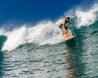 Team rider CJ Macias takes a critical drop on his Bizia wooden surfboard. 